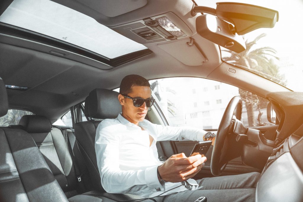man texting while driving car
