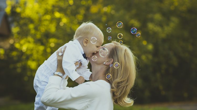 A mother holding her baby with bubbles in front of their faces