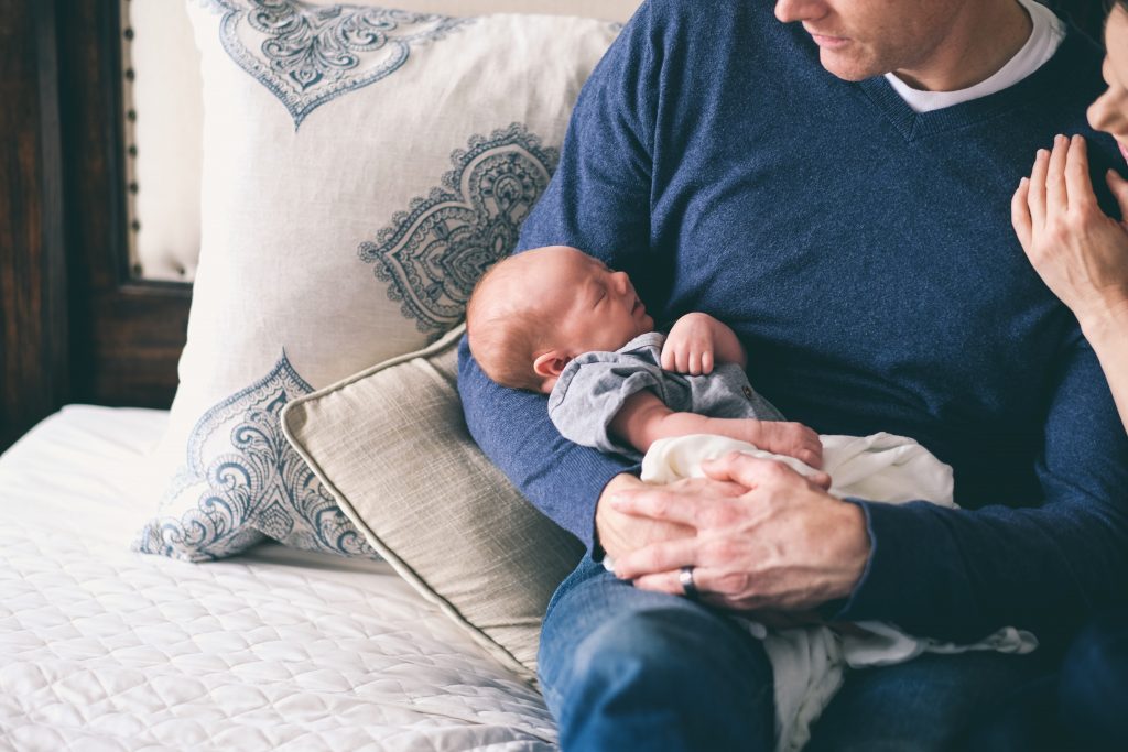 A father cradling a baby in his arms