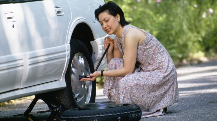 Woman changing a flat tire