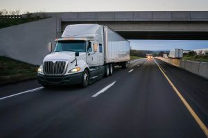 white 18-wheeler semi truck driving on the road