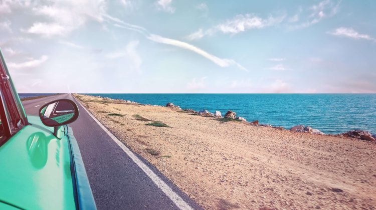 Car Driving on the Road Along a Beach