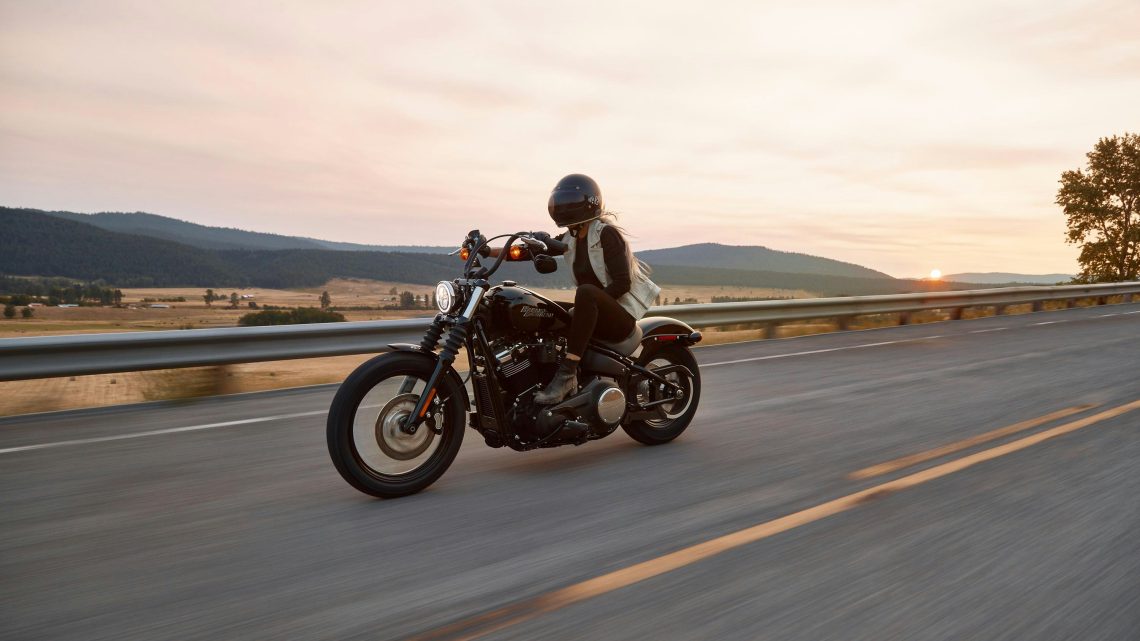 a personal riding a motorcycle on an open road