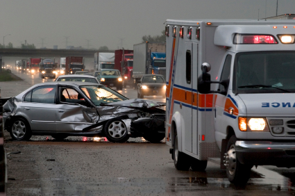 deadly car crash on dangerous North Carolina road. Ambulance on scene and dented car.
