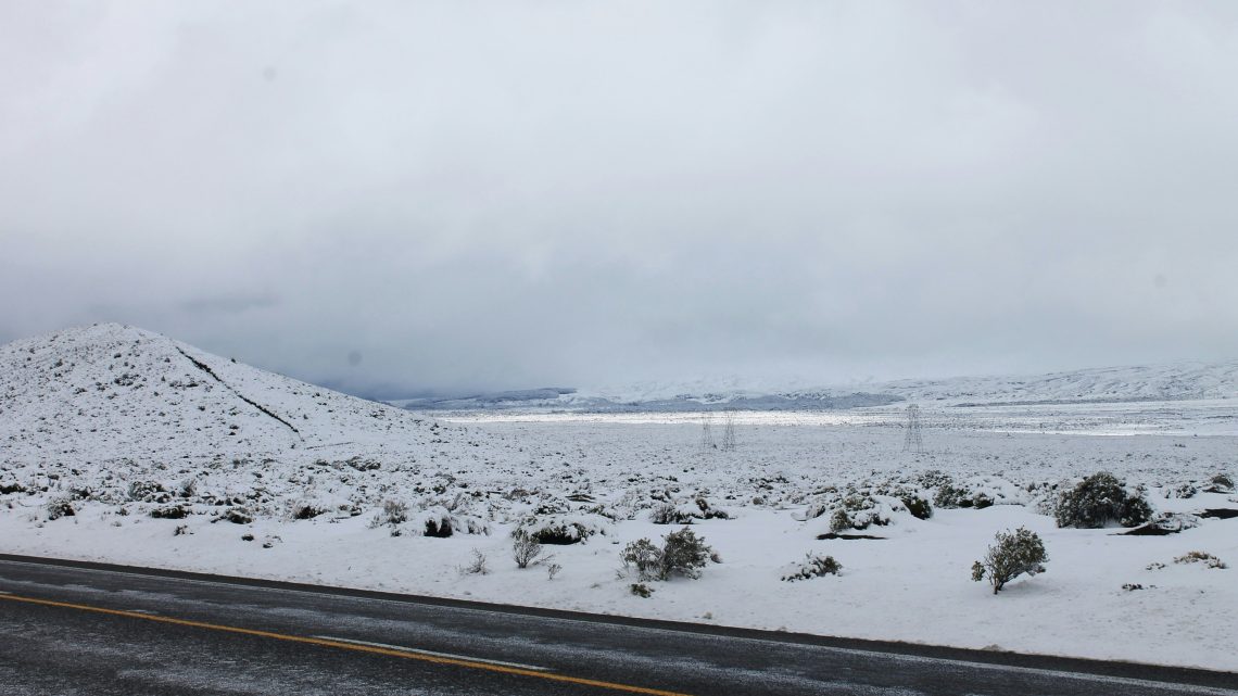 snow covered road with mountain in the back