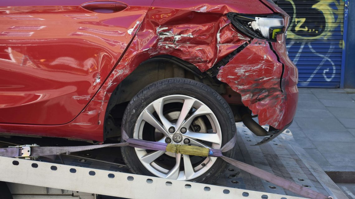 Wrecked Car Strapped Down to a Tow Truck